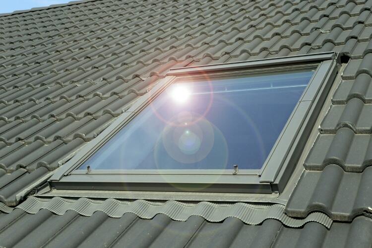 promienie słoneczne odbijające się w oknie dachowym